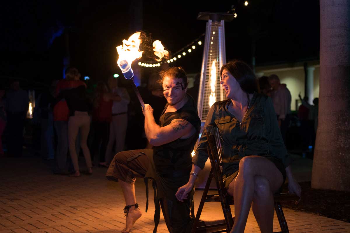 Fire dancer with thrilled guest at a fundraising event in Naples, Florida